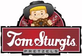 Tom Sturgis logo of a kid holding a pretzel