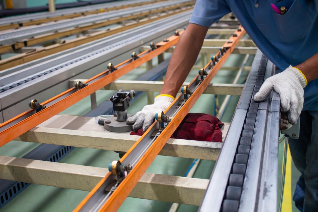 Employee cleaning a conveyor belt.