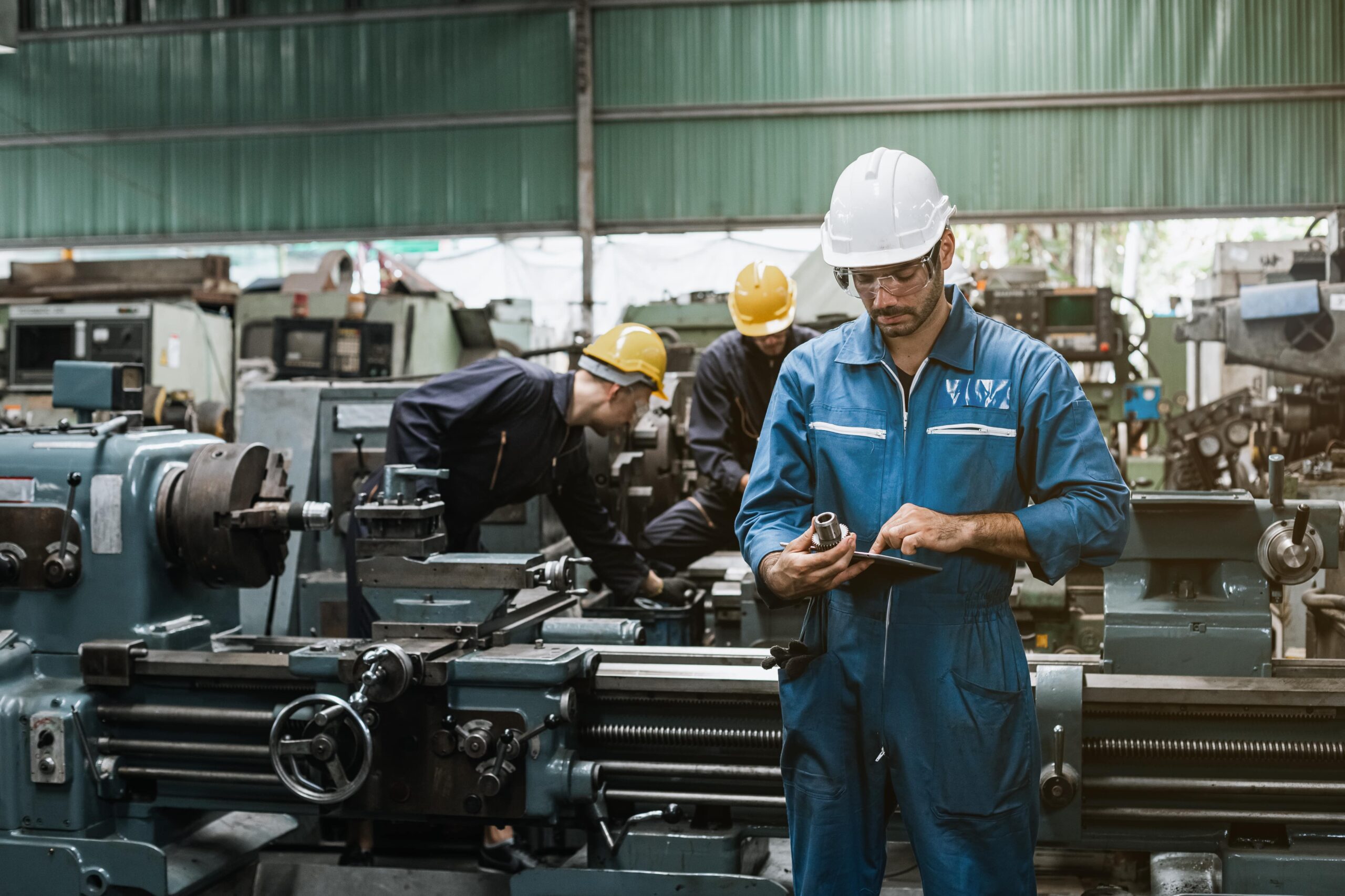 Worker checking conveyor belt components.